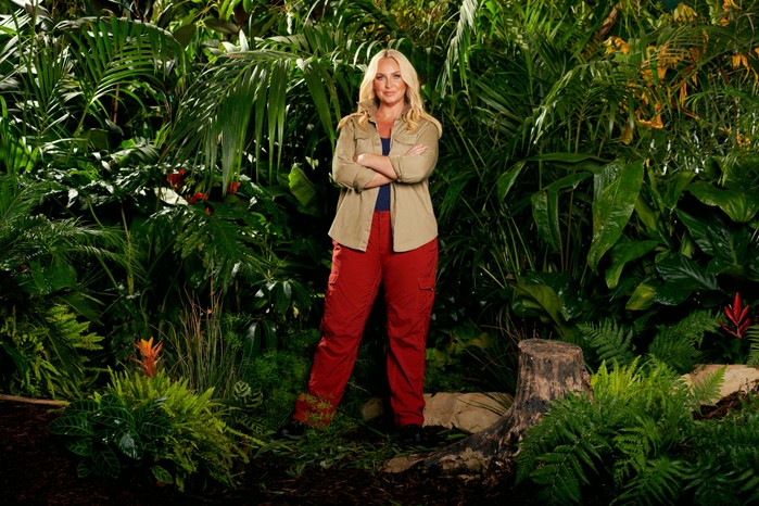 Josie-Gibson-on-I'm-a-Celebrity Josie Gibson wearing a khaki shirt and red trousers while posing in front of some bushes ahead of I'm a Celebrity 2023.